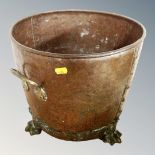 A 19th century hammered copper and brass coal bucket on paw feet,