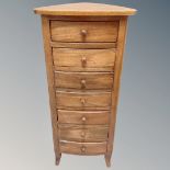 A triangular shaped corner chest of eight drawers