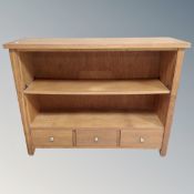 A contemporary oak bookcase fitted with three drawers