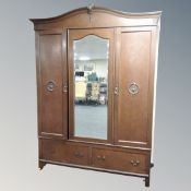 An early 20th century mirror door triple wardrobe