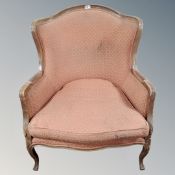 A French style beech framed armchair upholstered in salmon fabric