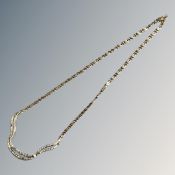 An 18ct yellow gold figaro type link necklace with three curved sections set with diamonds,