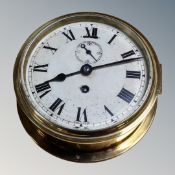 A circular brass cased wall time piece with silvered dial,