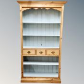 A pine bookcase fitted with three drawers,