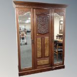 A Victorian walnut and mahogany triple mirrored door wardrobe with matching sunk centre dressing