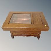 An oriental style table with glazed top and fitted with drawers