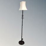 A wrought iron standard lamp with shade