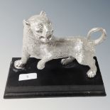 A white metal sculpture of a tiger on plinth