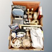 Two boxes containing table linen vintage tins, cased cutlery, brass candle holder etc.