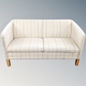 A continental cream and blue stitched two seater settee