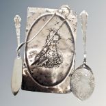 A silver emobssed panel together with a further silver pair of sugar tongs caddy spoon and butter