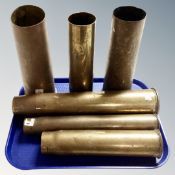 Six brass ammunition shells.