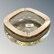 A heavy glass ashtray with white metal rim, probably silver.