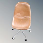 A contemporary tan vinyl swivel chair