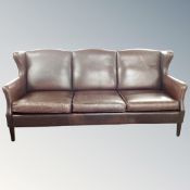 A brown leather continental three seater settee