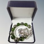 A green glass bead bracelet with silver setting and overlay with 925 beads of flowers and 1 other