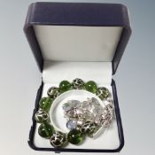 A green glass bead bracelet with silver setting and overlay with 925 beads of flowers and 1 other