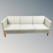 A cotemporary three seater settee in light green and cream fabric
