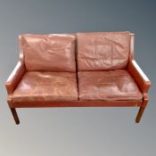 A continental burgandy leather two seater settee