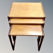 A nest of three teak mid century tables