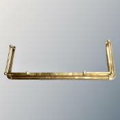 An antique brass extending fire curb.