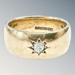A gent's heavy gauge 9ct gold band ring inset with a diamond weighing approximately 0.
