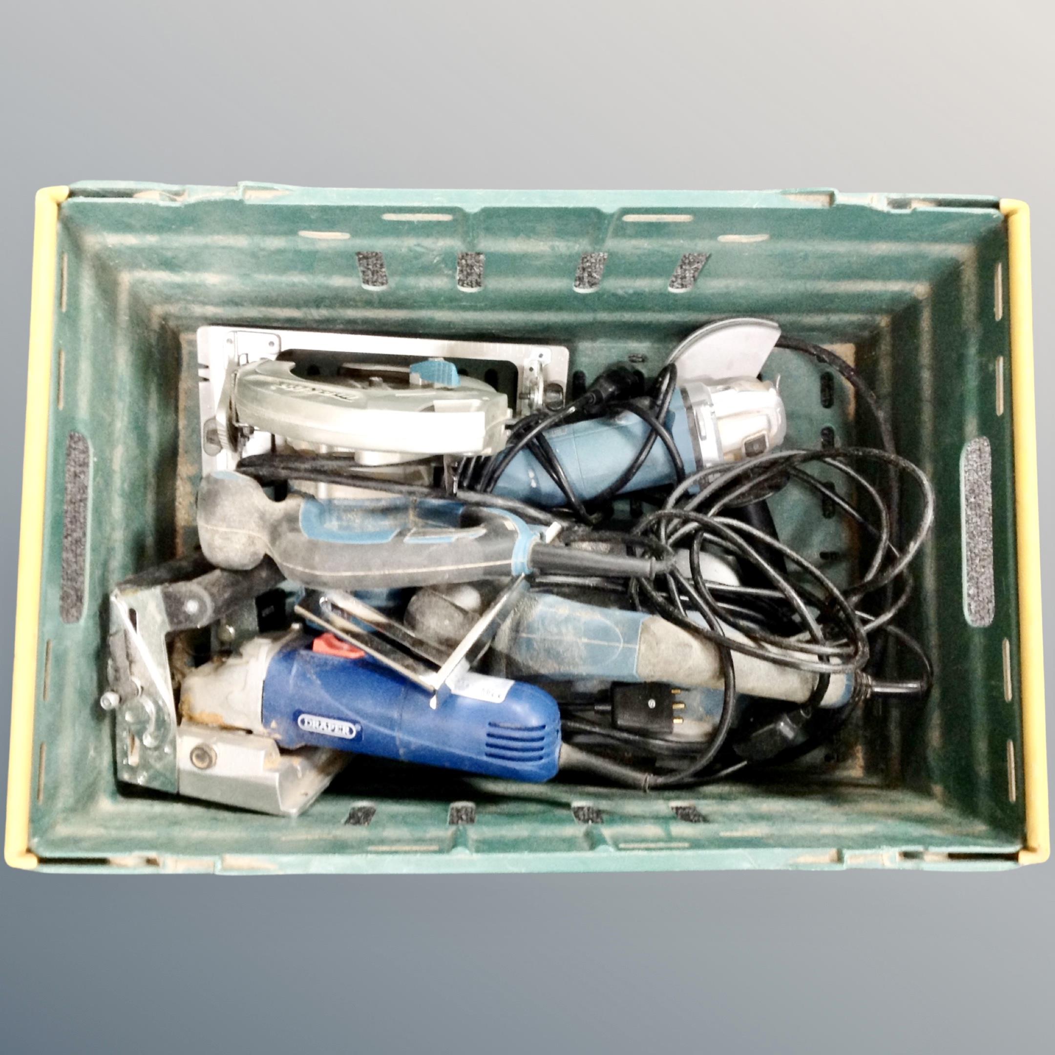 A crate containing power tools to include Makita hand saw, Erbauer angle grinder,