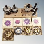 A quantity of metal cutter wheels mounted on a wooden stand together with four further boxed