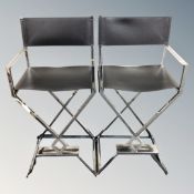 A pair of black stitched leather and steel high chairs