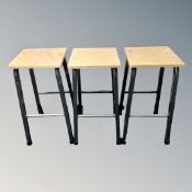 A set of three 20th century plywood topped laboratory stools on metal legs