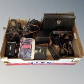 A crate of vintage cine and box cameras, Magic lantern, vintage field glasses,