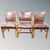 A mid century beech framed armchair in red studded leather together with pair of matching dining