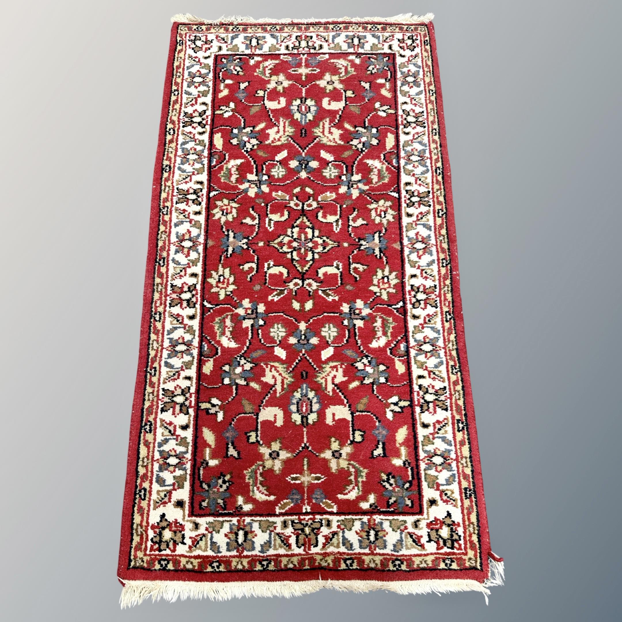 An Iranian red ground rug 143 cm x 76 cm