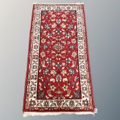 An Iranian red ground rug 143 cm x 76 cm