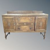 An Edwardian oak double door sideboard fitted with two drawers on raised legs