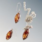 A silver and amber pendant on chain with matching earnings.