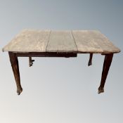 A 19th century oak wind out table with leaf