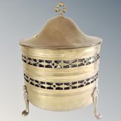 An antique brass lidded coal bucket with liner on raised feet.