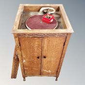 An early 20th century oak cased floor standing gramophone in cabinet (a/f) together with a box