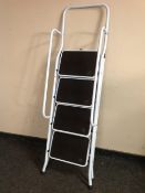 A four tread folding step ladder with twin hand rail