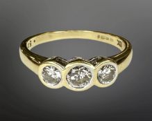 An 18ct gold three stone diamond set ring, the stated total diamond weight 0.50 carat, size N.
