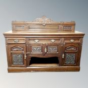 A carved oak rail backed Arts and Crafts sideboard