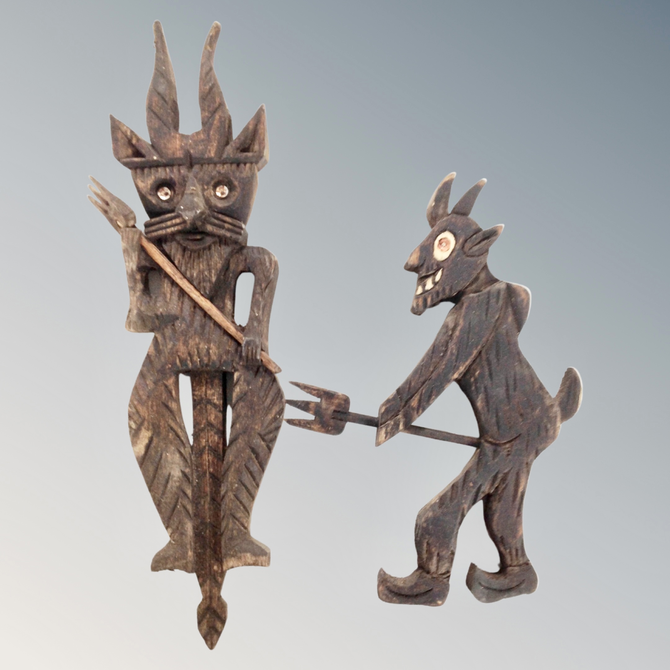 Two carved wooden devil figures