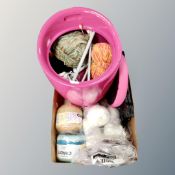 A box containing storage stool containing a quantity of wool oversized knitting needles,