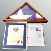 A folded Texas flag in triangular display frame which was presented to Dr.