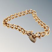 A gilt curb bracelet with padlock.