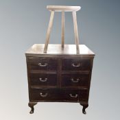 A 20th century five drawer chest in a mahogany finish together with an oak milking stool