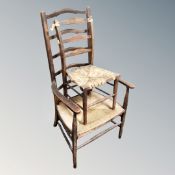 An Arts and Crafts beech ladder backed armchair with rush seat and further similar child's chair