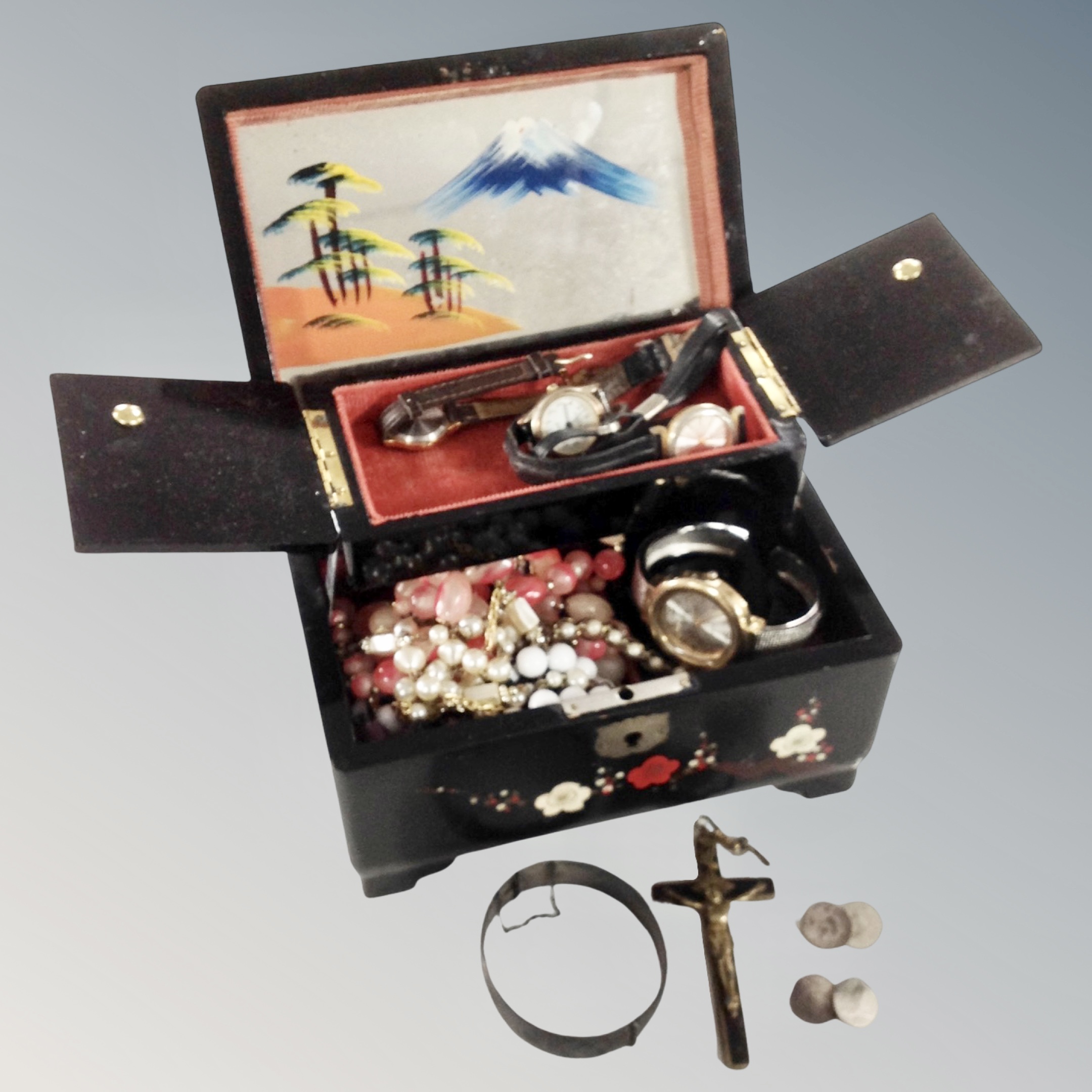 A 20th century oriental black lacquer musical jewellery box containing assorted wristwatches,