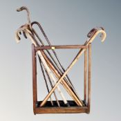 An Edwardian oak stick stand with lift out tray together with a quantity of assorted walking sticks,